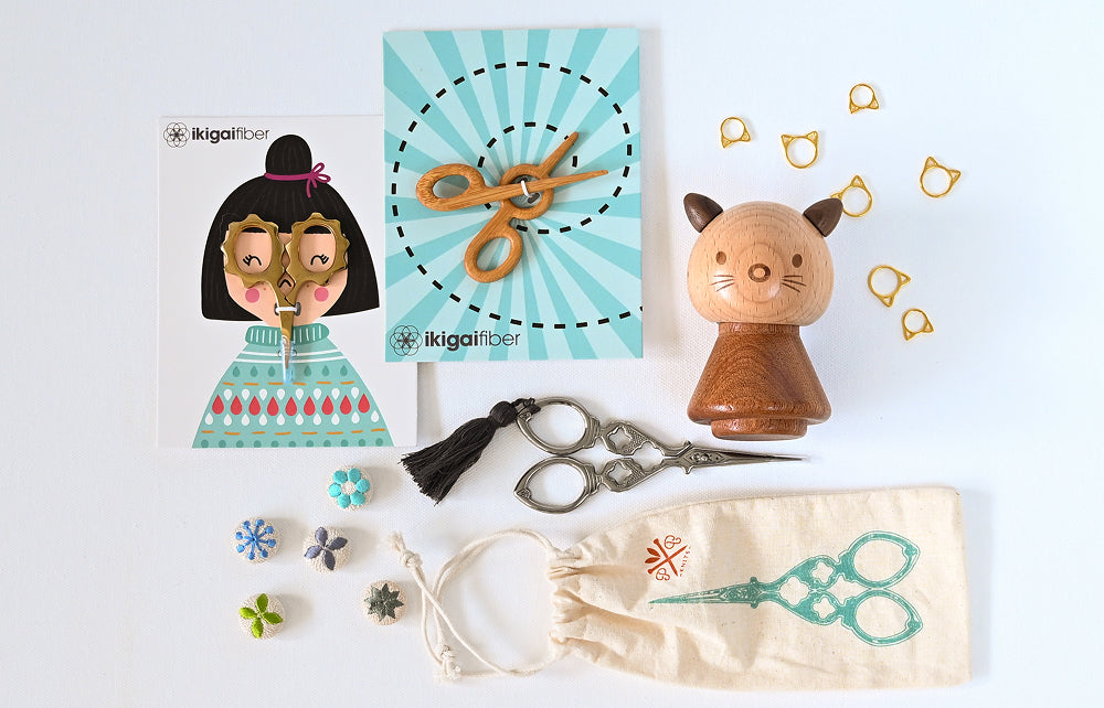 Collection of craft supplies including a paper cutout, scissors, and decorative items on a white background.
